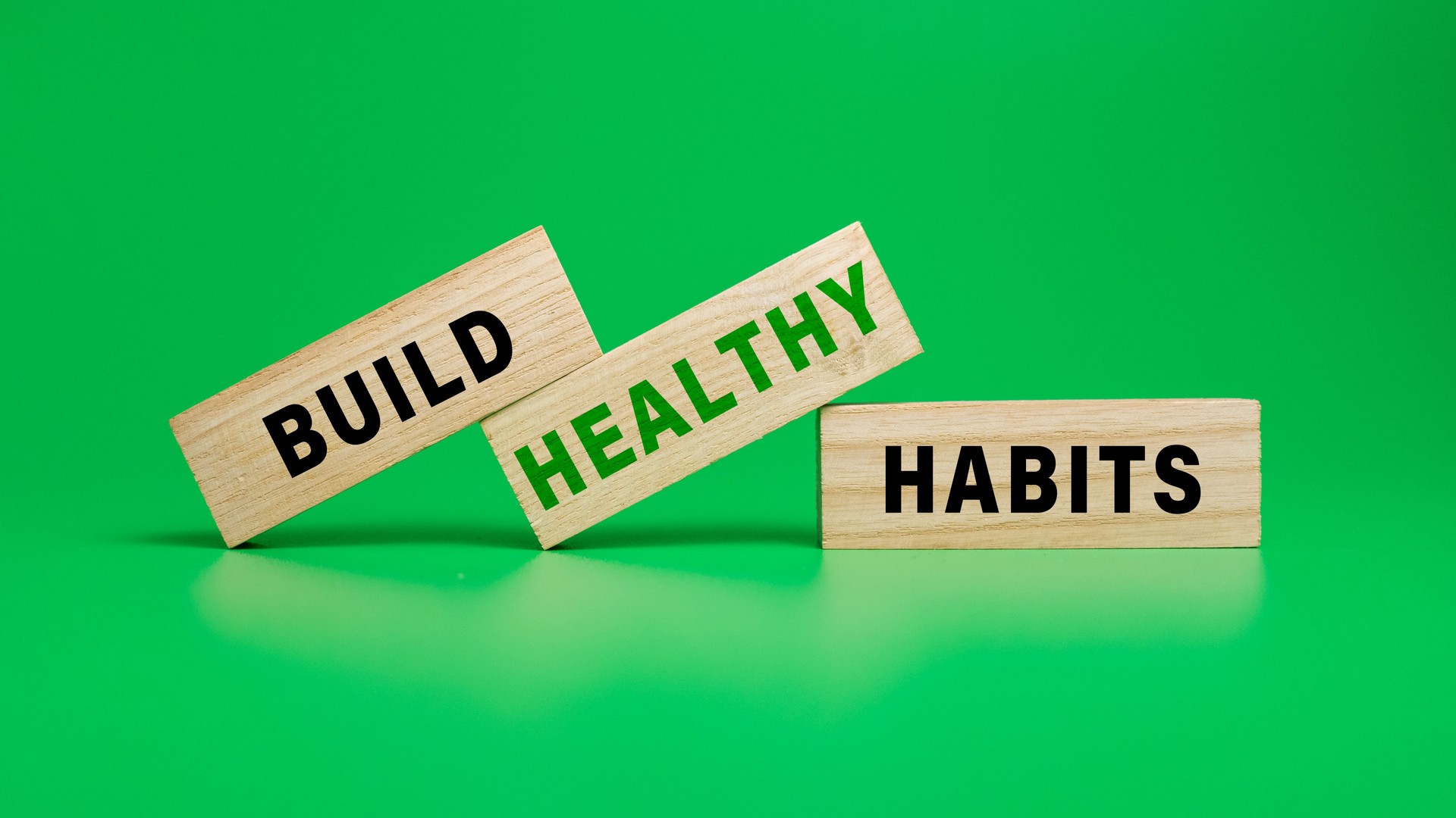 build healthy habits on wooden blocks isolated on green background